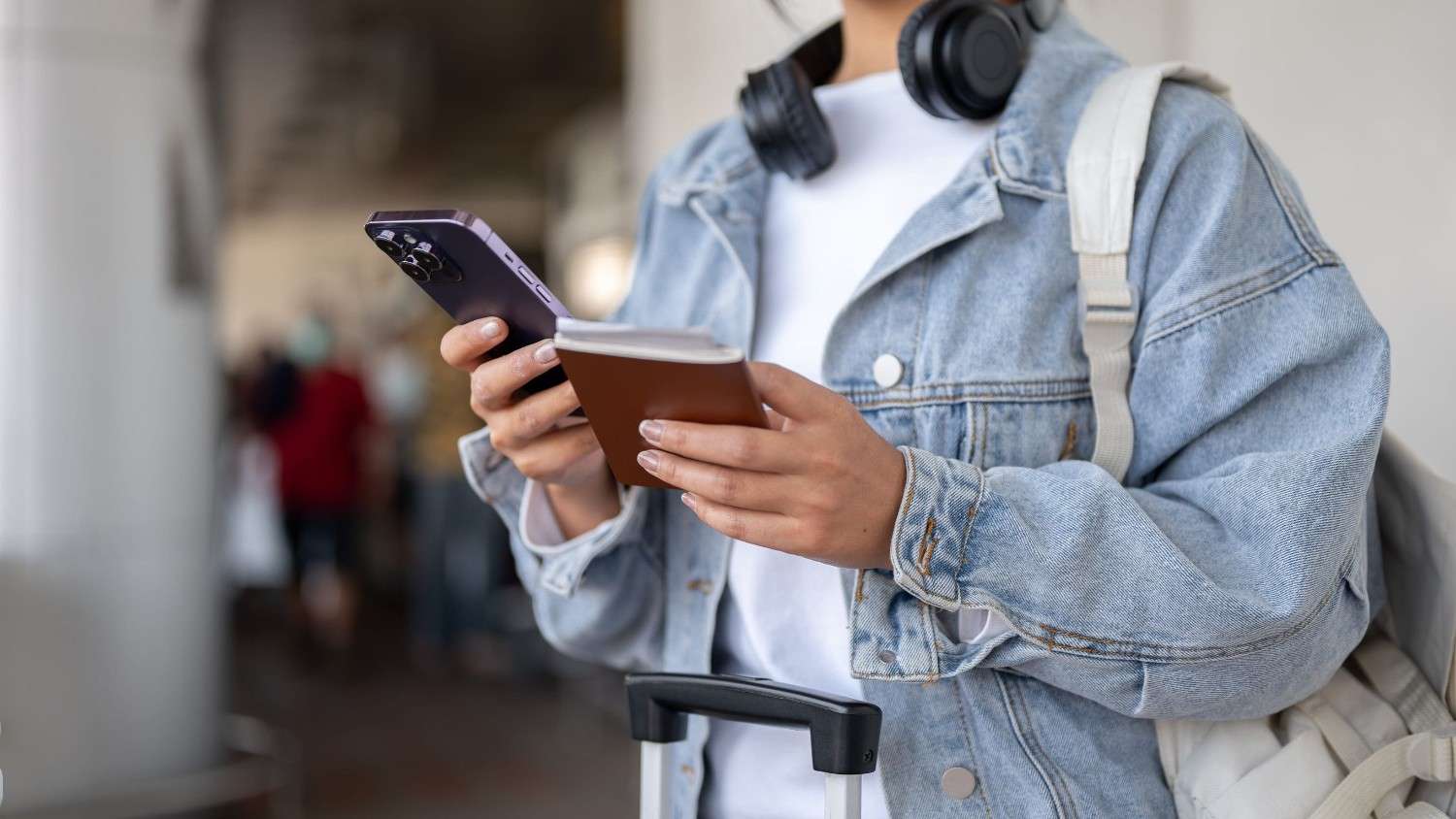 A Female Holding A Passport And A Smartphone