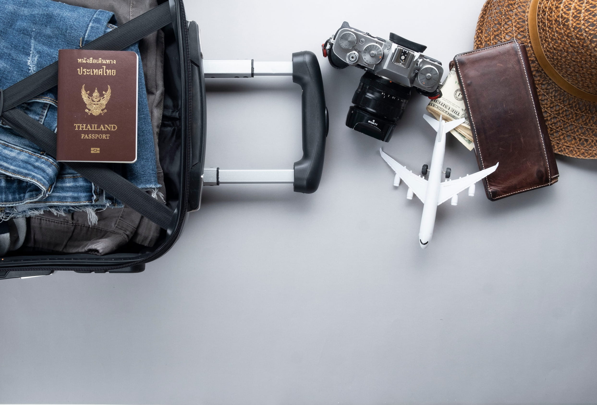 Open suitcase with packed items and other travel stuff lying