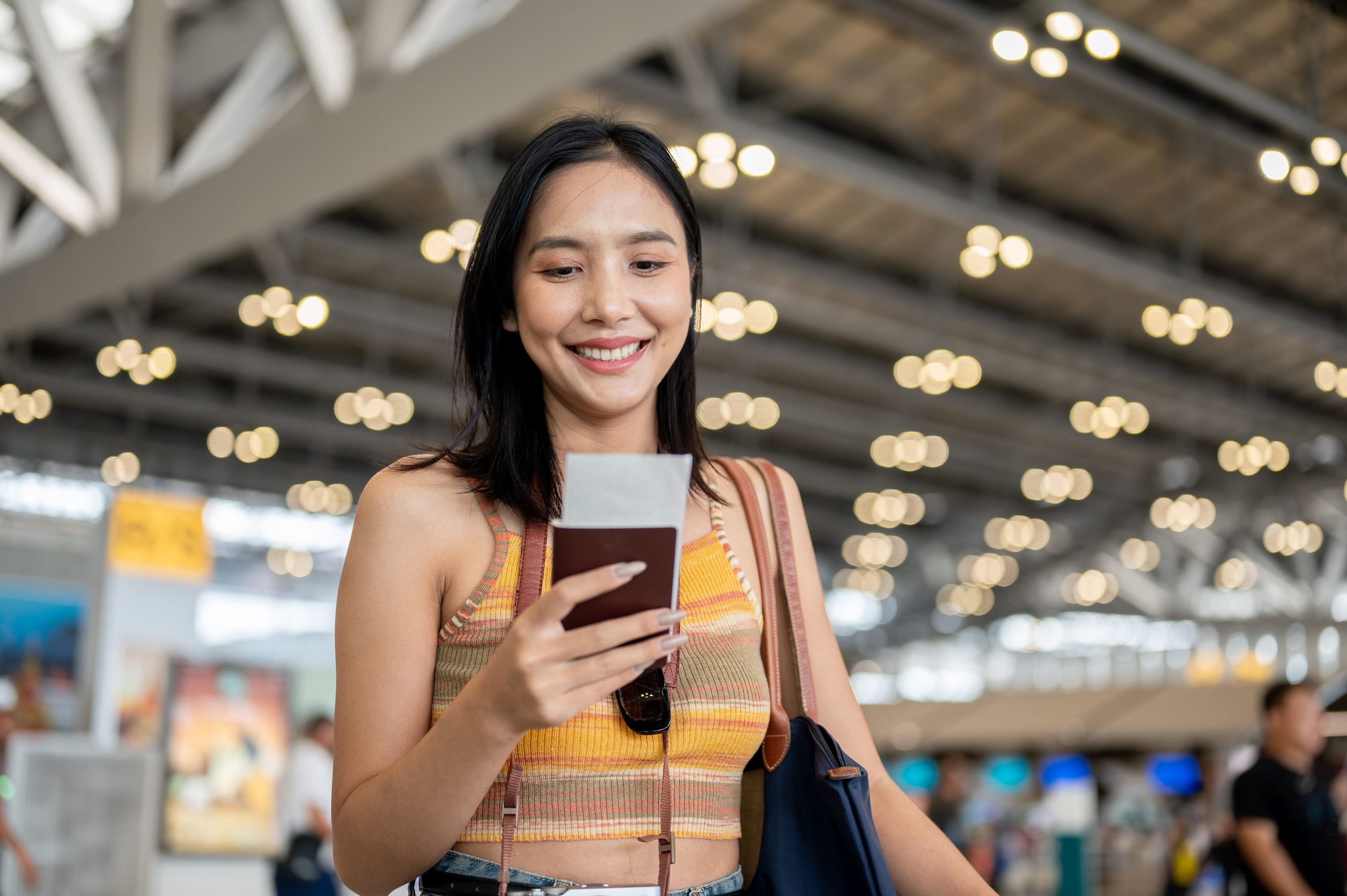 Smiling Young Tourist Holding Passport At Airport
