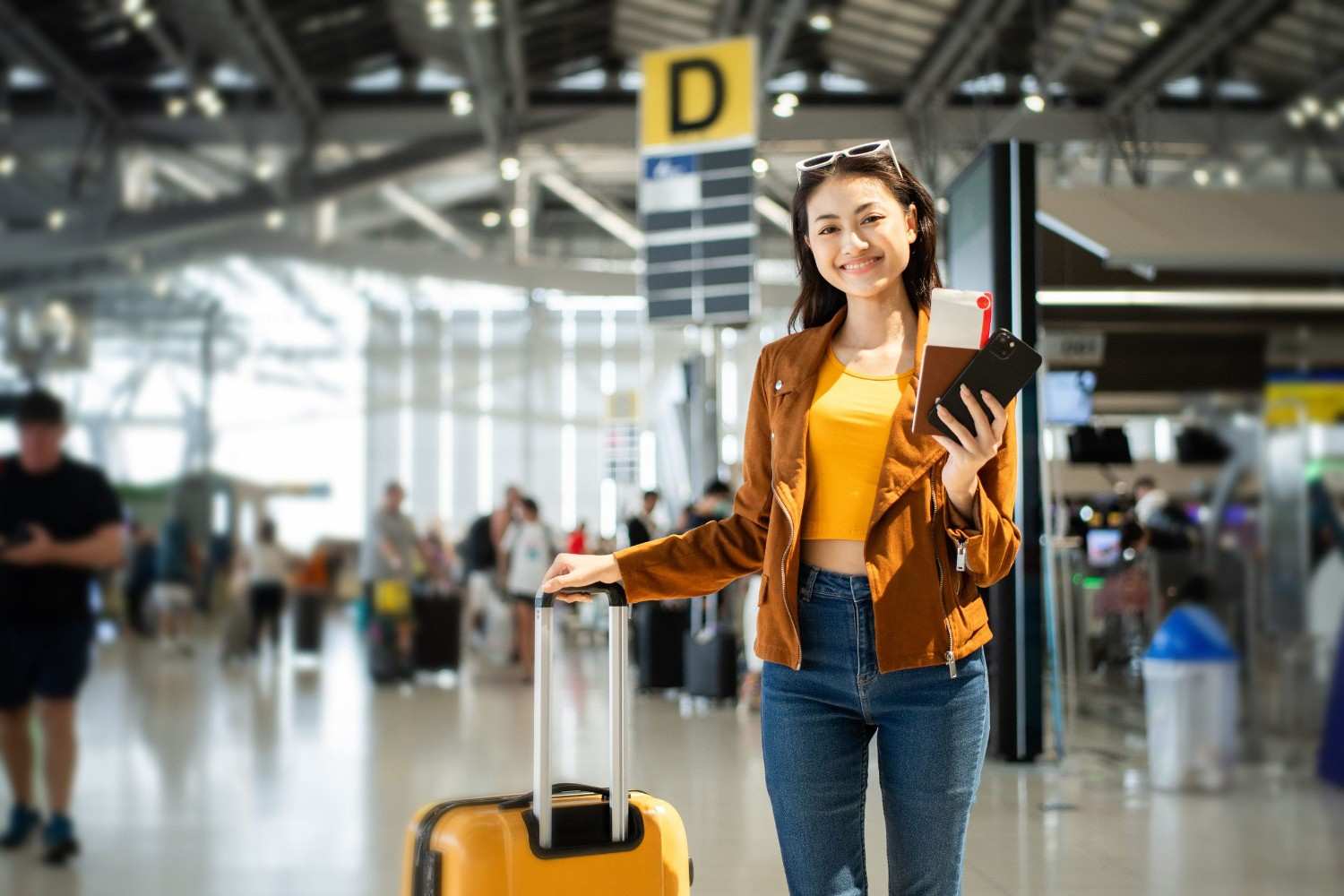 Woman Traveler Holding Passport Boarding Pass And Smartphone At Airport